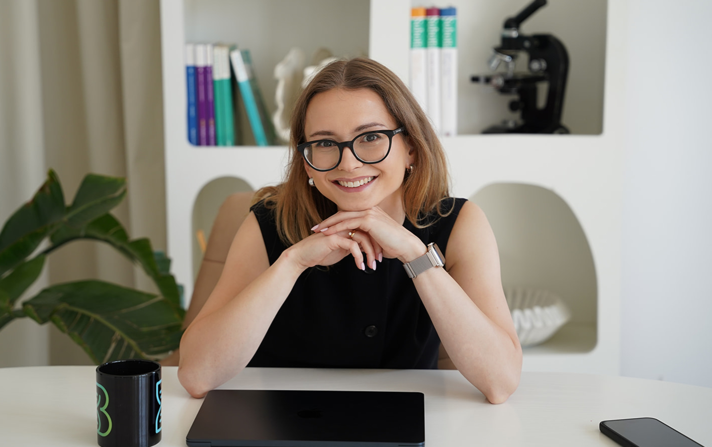 Ela, biolog i autorka merytoryczna Bioverse, przy biurku z mikroskopem i podręcznikami do biologii